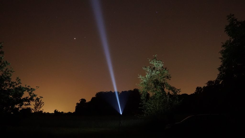 Thrower Taschenlampe leuchtet in Nachthimmel